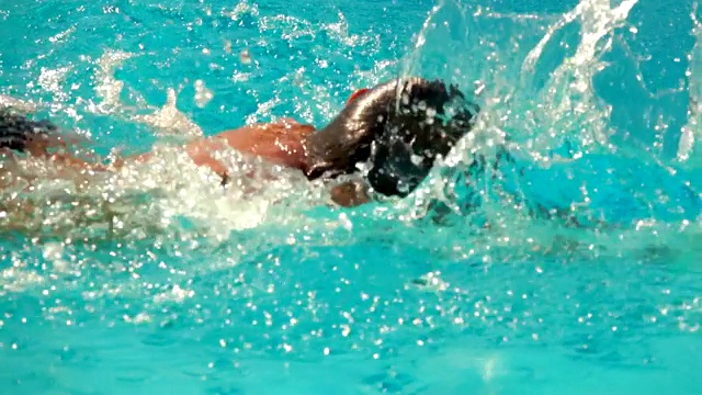 男孩在游泳池里以爬泳的姿势游泳视频下载