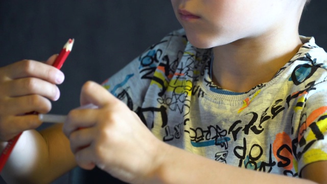 一个六岁的孩子在削彩色铅笔。视频素材