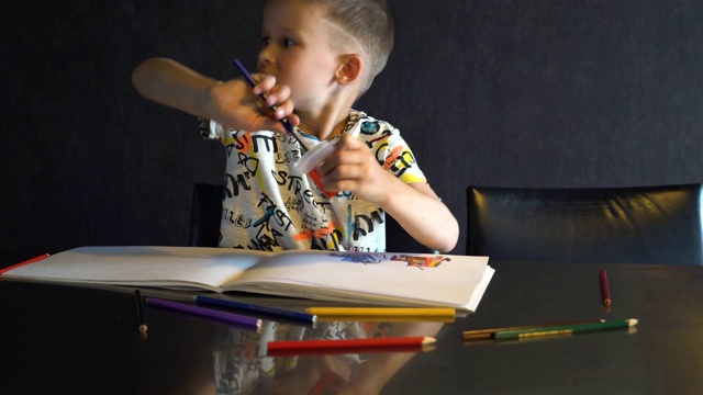 一个六岁的孩子在削彩色铅笔。视频素材
