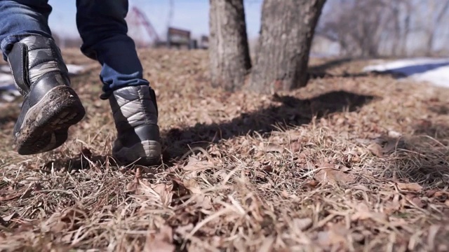 一个孩子在草地上走。特写视图视频素材