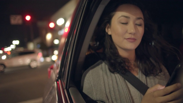 一名年轻女子晚上坐在车里视频素材