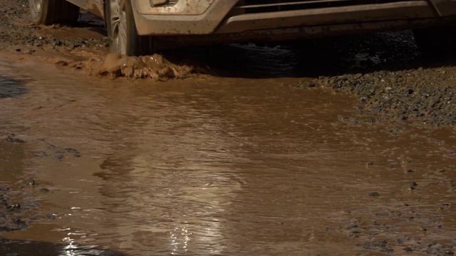 汽车在泥泞的水坑中行驶视频素材