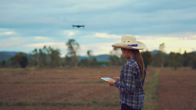 农民妇女与数字平板控制无人机农业技术在稻田梯田视频下载