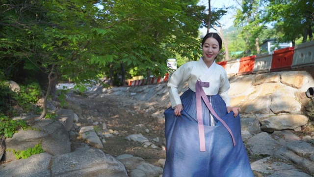 身着韩服(朝鲜王朝传统服饰)的女子在森林里散步视频下载
