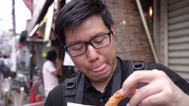 饥饿的男人在吃天妇罗虾。视频素材