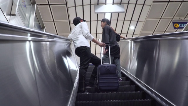 一对年轻夫妇带着行李上了自动扶梯视频下载