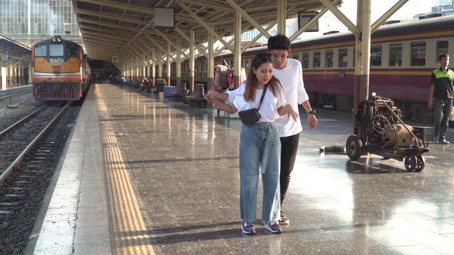 一对年轻的情侣在火车站跳舞视频素材