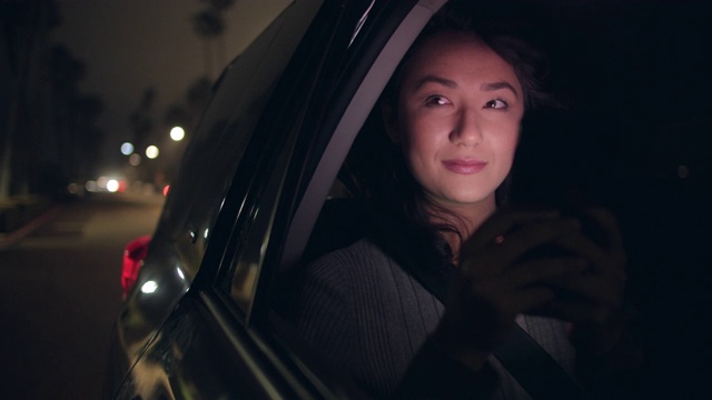 CU - SM年轻女子晚上在汽车后座上旅行视频素材