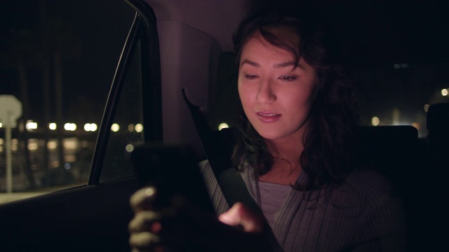一名年轻女子在车里用手机视频素材