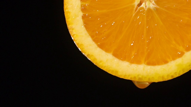 慢动作:水从橙色切片上滴下一滴水视频素材