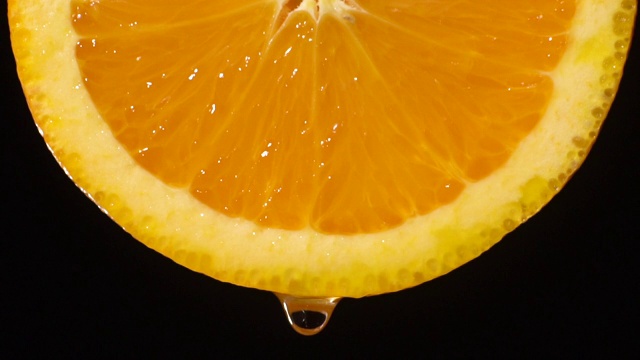慢动作:水从橙色切片上滴下一滴水视频素材
