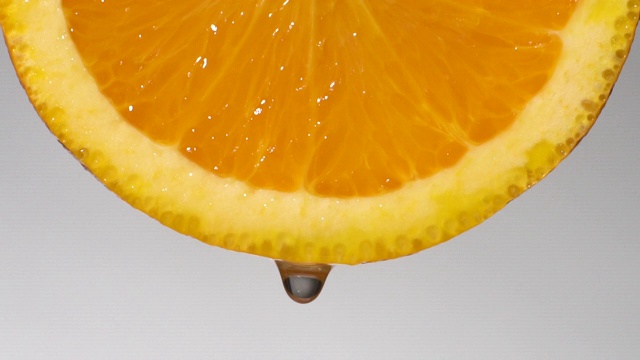 慢动作:从白色的橘子片上滴下一滴水视频素材