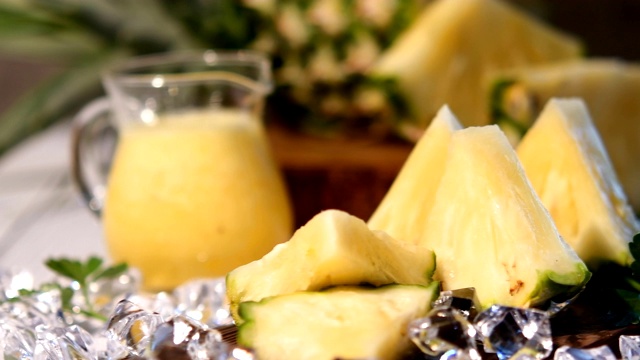 深色背景上加冰和菠萝的菠萝鸡尾酒或果汁，桌上放有新鲜菠萝切片的木板视频下载