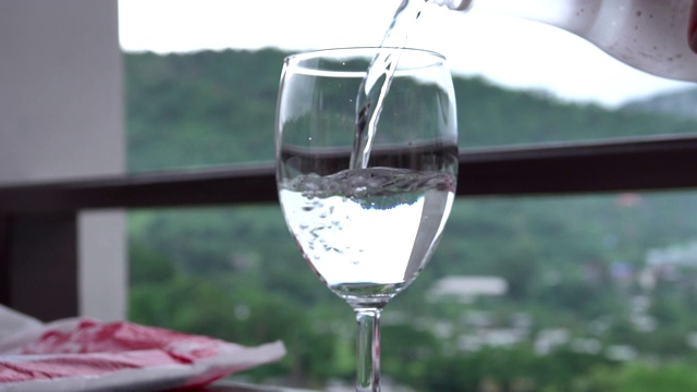 从山景桌上的水罐中倒出纯净的新鲜饮用水视频素材