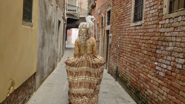 后视图的妇女穿着历史服装走在狭窄的小巷视频素材