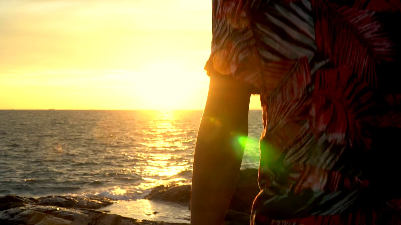 4K视点起重机拍摄剪影自由年轻的亚洲男人旅行者在休闲装走在海洋岛屿山悬崖在夏天日落在假期旅行日落黄昏天空和海洋背景视频下载