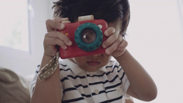 快乐的小男孩用玩具相机拍照视频下载