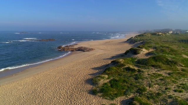 空中向前缓慢:美丽的海滩庞托葡萄牙与海浪平静地触摸该地区的沙子-波尔图，葡萄牙视频下载