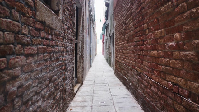 穿着狂欢节服装和威尼斯面具的男子在狭窄的小巷里跳跃视频下载