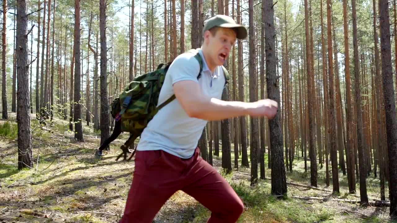 跟踪右边的镜头，两个非常害怕的年轻人背着背包在森林里奔跑，慢动作逃离危险，尖叫得非常可怕视频下载
