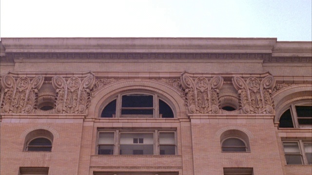 中等上角度的建筑与玛雅建筑装饰在顶部拱形窗户。可能是政府建筑学校。视频下载