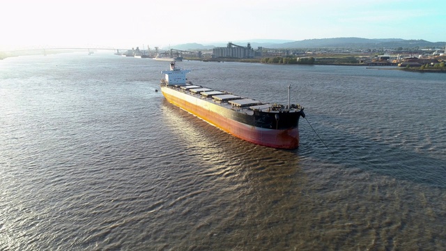 停靠在美国俄勒冈州和华盛顿州边界的哥伦比亚河上的货船。无人机用轨道摄像机拍摄低空视频运动。视频下载