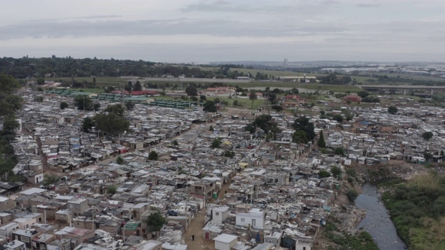 4K空中俯瞰贫民窟或棚户区沿Jukskei河在亚历山德拉镇，南非视频素材