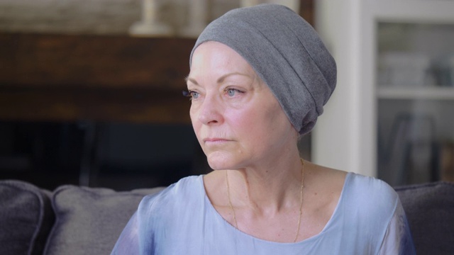 一位身患癌症的妇女坐在家里的沙发上视频素材