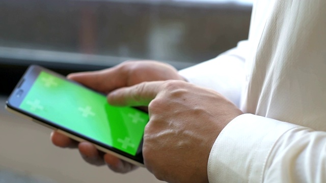 商人正在开发绿色屏幕的智能手机视频素材