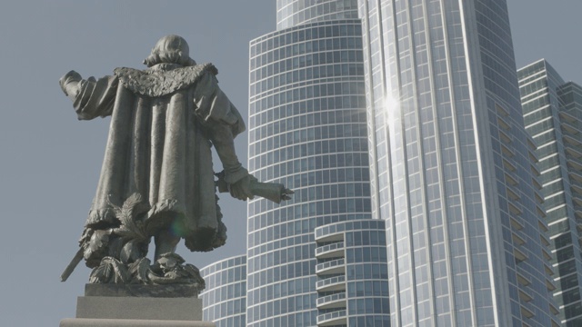 中等角度的雕像或雕塑克里斯托弗哥伦布在格兰特公园在芝加哥。玻璃摩天大楼或高层在bg。可以是公寓、酒店或办公楼。视频素材