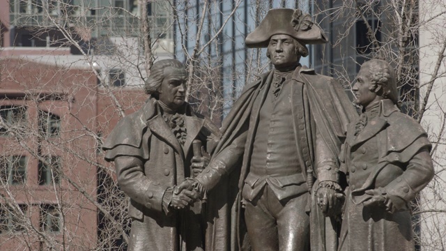 中等角度的雕像或雕塑的乔治华盛顿，罗伯特莫里斯，和海姆萨洛曼在芝加哥。综广场。建筑物部分可见在bg。视频素材