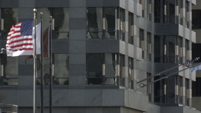 玻璃办公大楼或酒店前旗杆上美国国旗的中角。国旗读取“文艺复兴”。城市。视频素材