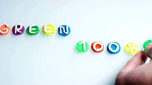 一个放大镜悬空在“绿色100%”的字样上，这是一个孩子们创作和艺术的作品。视频素材