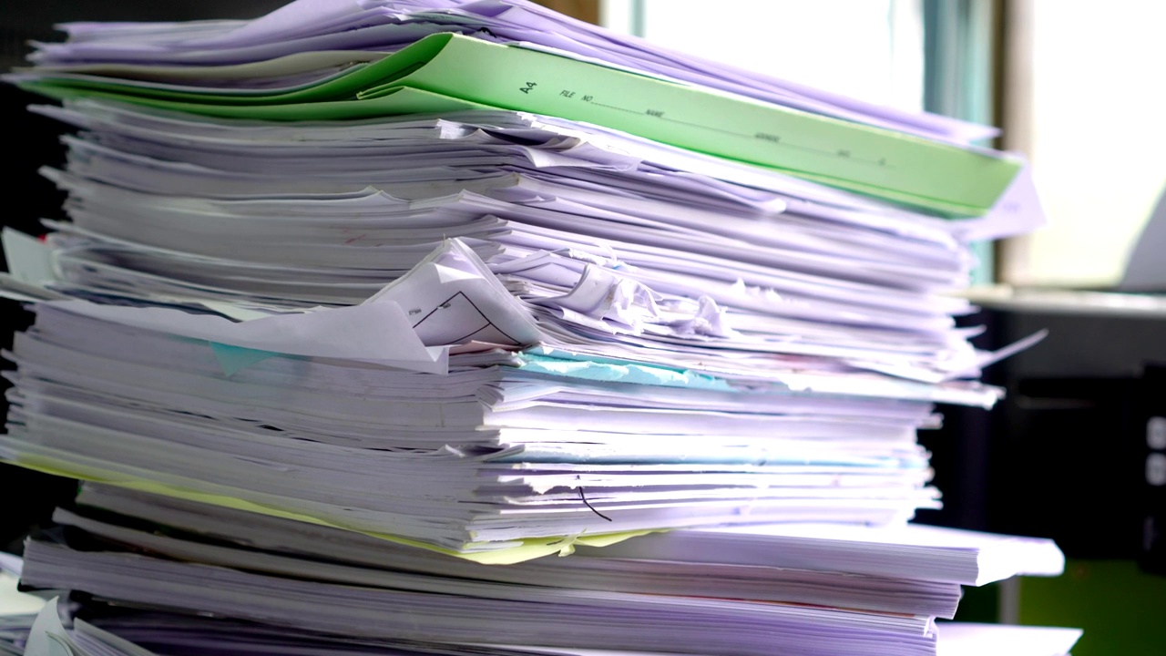 堆得很高的回收文件文件夹，把商务文件堆在凌乱的桌子上或办公室的文书工作。旧文件以打印文件夹的形式保存，可循环使用以保存视频素材