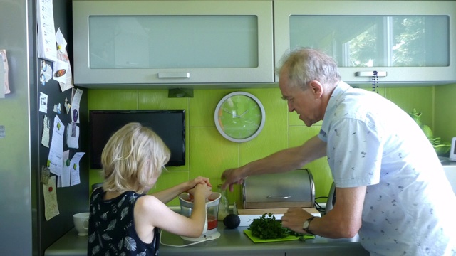 爷爷和孙子在厨房准备健康的食物。视频下载