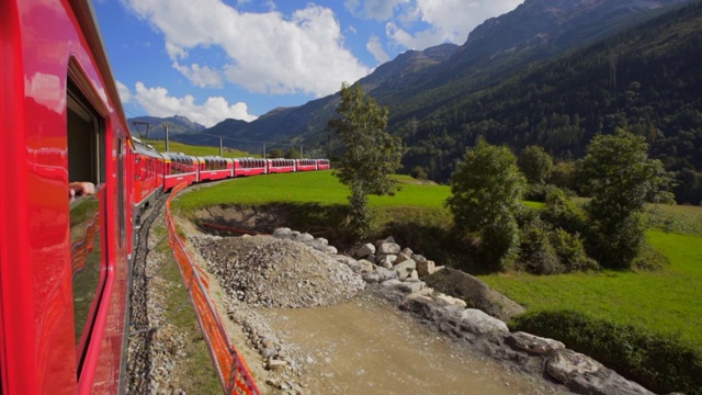 红色火车的一边从窗口与山脉和农田-瑞士阿尔卑斯山，瑞士视频素材