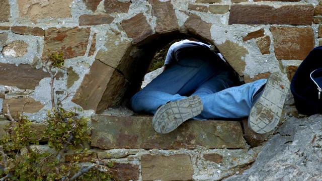 那个年轻人从墙上的洞里爬了出来。视频下载