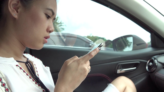 坐出租车，用智能手机上网的亚洲女性视频素材