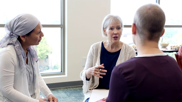 在乳腺癌支持小组会议上，关怀女性顾问与有问题的女性交谈视频素材