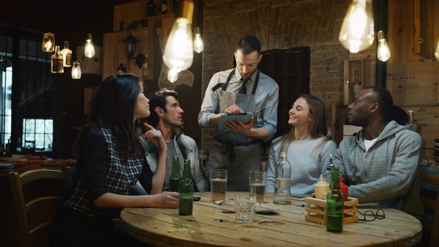 酒吧里年轻的朋友们向服务员点菜的慢动作。视频下载