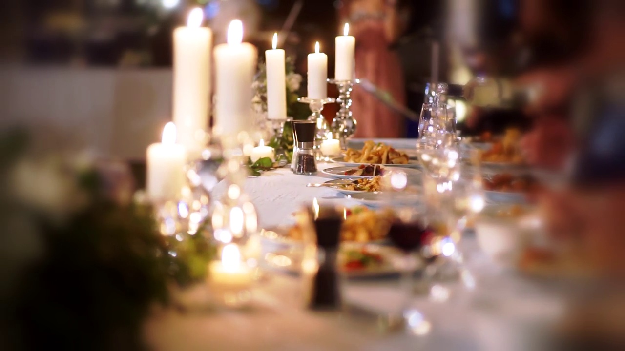 为婚宴或宴会准备的软焦点餐桌，配有餐具和蜡烛。视频素材