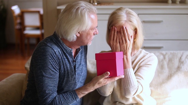 体贴的老丈夫给兴奋成熟的妻子送礼盒视频素材