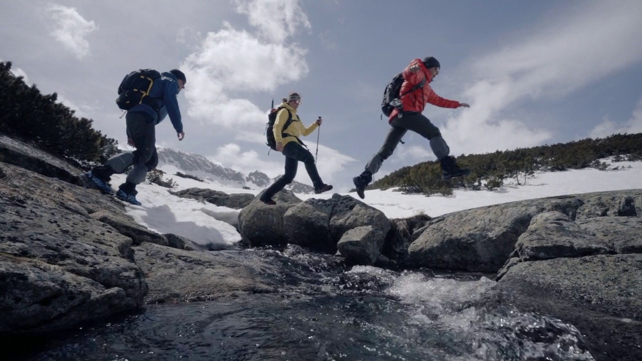 徒步旅行者在山中翻越河流视频下载