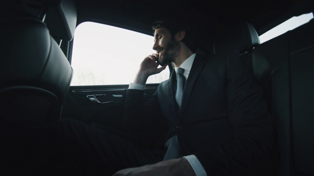 慢动作的年轻英俊的商人看在一个现代汽车旅行期间与一个司机在市中心的白天。视频下载