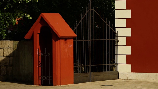 红褐色和白色建筑旁的金属栅栏视频下载