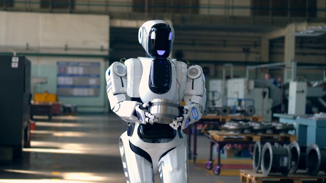 机器人正带着一件金属物品穿过工厂视频素材