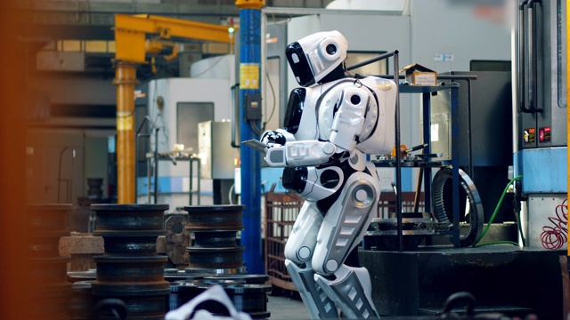 金属工厂，一个机器人在观察它视频素材