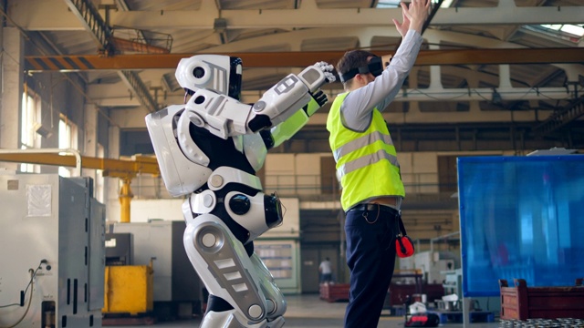 机器人跟着戴着虚拟现实眼镜的人重复动作视频素材