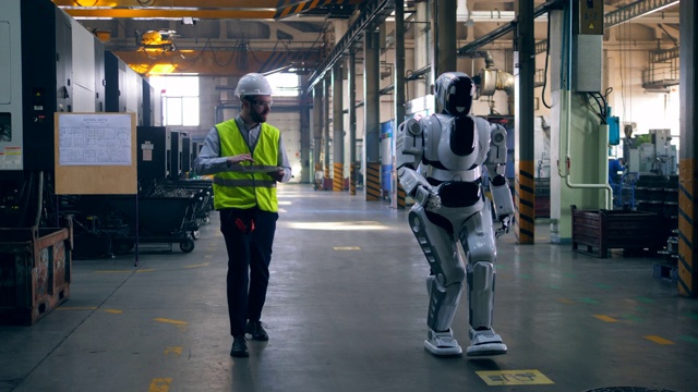 人形半机械人和一名男性技术员正在行走视频素材