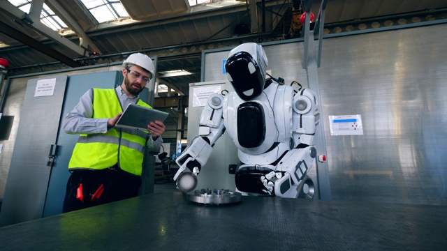 工厂工人正在控制一个机器人抛光一个金属圆盘视频素材